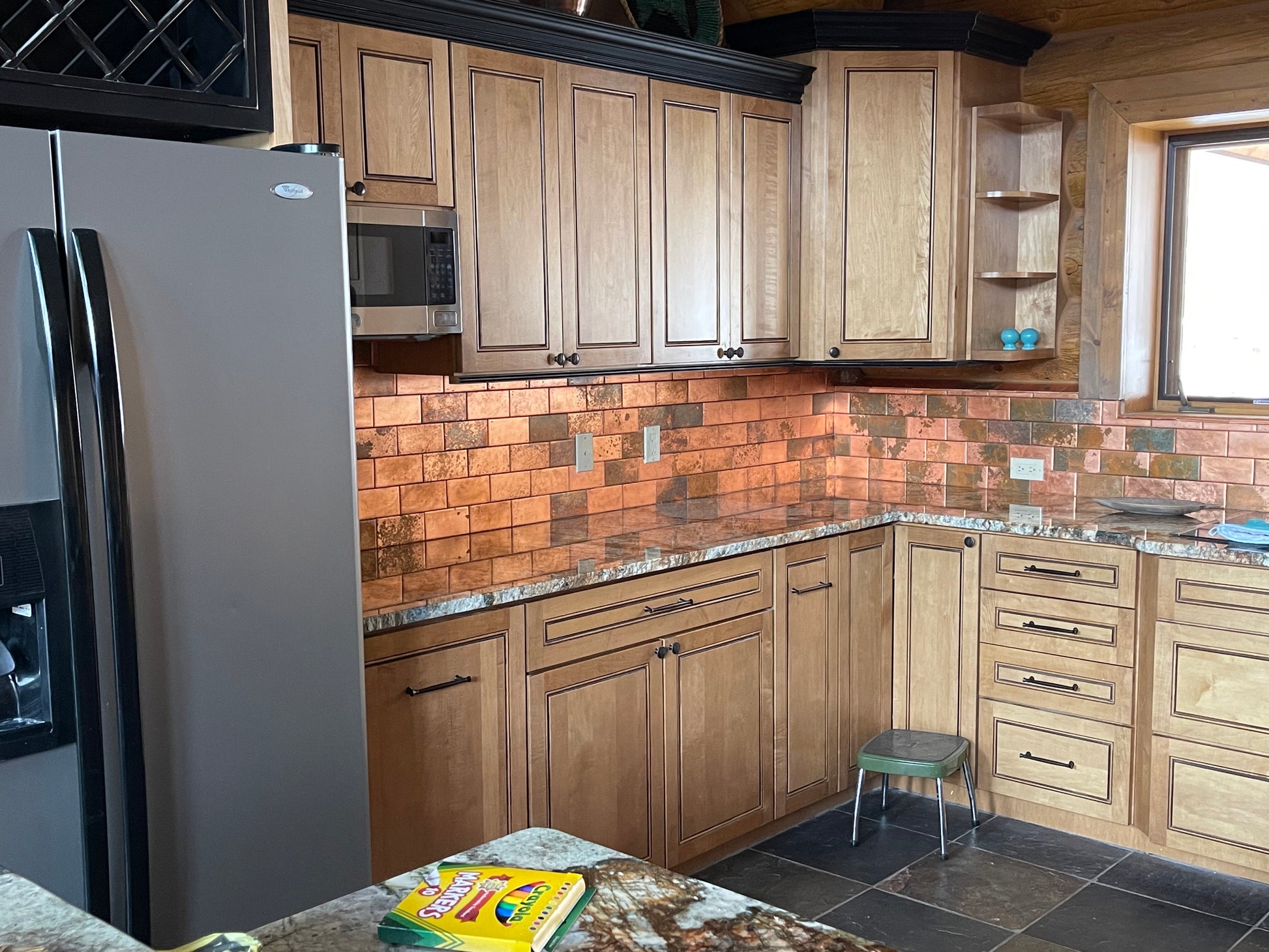 Kitchen with wooden cabinets, tiled backsplash, and stainless steel appliances.